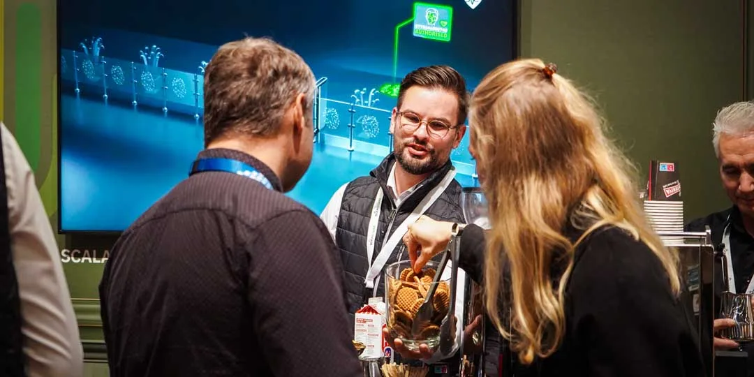 An exhibitor presenting their security solution to visitors at a stand at SKYDD. 