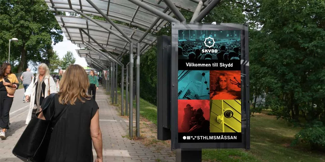 Besökare går längs gångvägen mot Stockholmsmässan, med digital skylt som välkomnar till mässan Skydd.