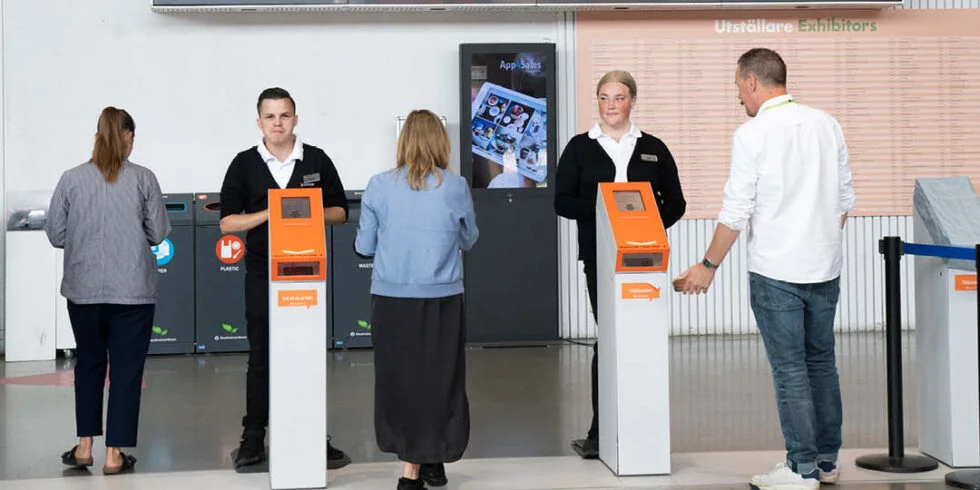 Entrékontroll med biljettutskrifter och personal som hjälper besökare.