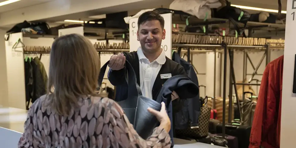 Personal tar emot en väska i garderoben på Stockholmsmässan